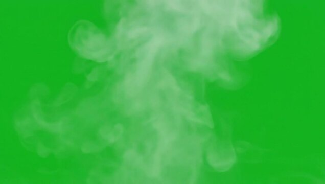 Clouds of smoke rising from an unknown source on a green background viewed from a straight-on perspective