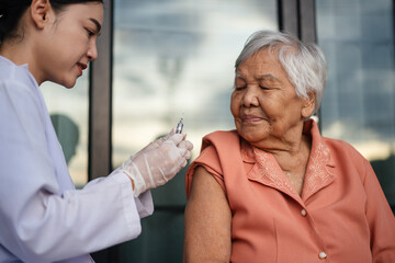 doctor holding syringe and making injection vaccine to senior woman