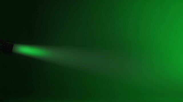 Green spotlight beam shining through dark smoky background, dramatic stage lighting effect with volumetric rays and atmospheric haze, cinematic studio illumination scene, concert projector glow in mis