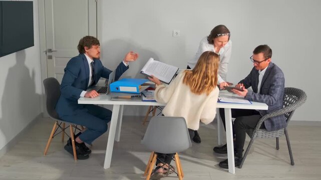 team reviews plans, strategic discussion among caucasian team reviewing various documents and notes, group of professionals engaged in resource planning and aligning project agendas collaboratively