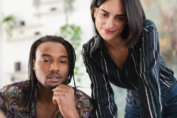 Two diverse colleagues, a man and a woman, are engaged in a focused discussion in a modern office setting. They are collaborating on a project, sharing ideas and insights.