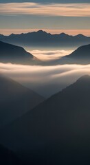 A breathtaking view of layered mountain ranges during sunrise with clouds filling the valleys and a soft glow illuminating the peaks