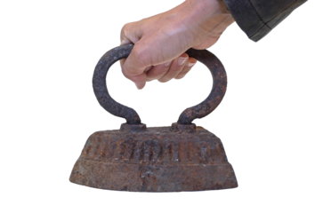 The hand holds an old cast-iron iron with rust. The object is isolated on a transparent background..