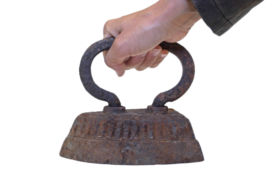 The hand holds an old cast-iron iron with rust. The object is isolated on a transparent background..