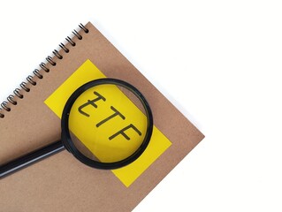 The word ETF written on notebook with white background. Financial or investment concepts. Copy space 