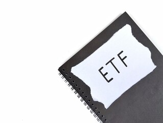 The word ETF written on notebook with white background. Financial or investment concepts. Copy space