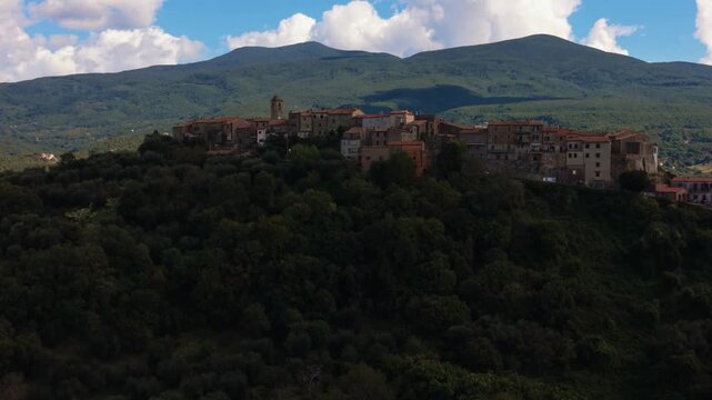 Montegiovi old town village on a hill with panoramic views of Monte Amiata and forest landscape. Aerial