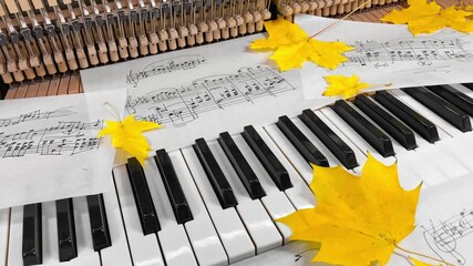An Old Upright Piano in Autumn: Handwritten sheet music and vibrant maple leaves rest on the keys, with the inner hammer mechanism visible, creating a nostalgic scene of seasonal musical inspiration
