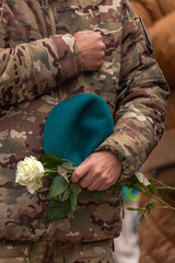 Ukrainian army. Memory of the dead. Russian-Ukrainian war. Ukrainian soldiers. Flowers in a man's hand. Honoring the memory. Posthumous ceremonies. Funeral bouquet. Military brotherhood.