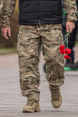 Ukrainian army. Memory of the dead. Russian-Ukrainian war. Ukrainian soldiers. Flowers in a man's hand. Honoring the memory. Posthumous ceremonies. Funeral bouquet. Military brotherhood.