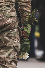 Ukrainian army. Memory of the dead. Russian-Ukrainian war. Ukrainian soldiers. Flowers in a man's hand. Honoring the memory. Posthumous ceremonies. Funeral bouquet. Military brotherhood.