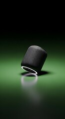 A sleek, modern portable speaker with a cylindrical shape, black mesh exterior, and a minimalistic design set against a vibrant green background