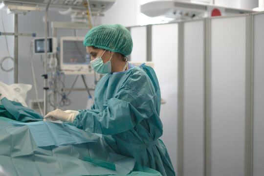 Surgeon performing operation in operating room with medical equipment