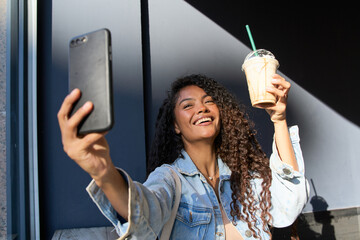 Woman taking selfie holding iced coffee drink