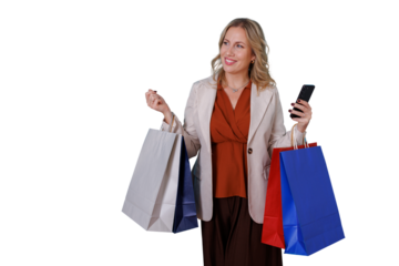 Happy woman holding shopping bags and phone while enjoying retail therapy, shopping spree concept