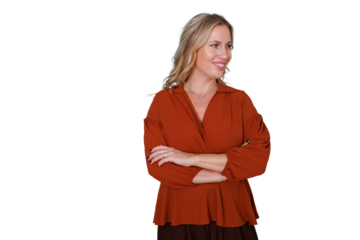 Mature blonde woman smiling and looking sideways, standing with arms crossed, portraying confidence, professionalism, and success. Transparent background