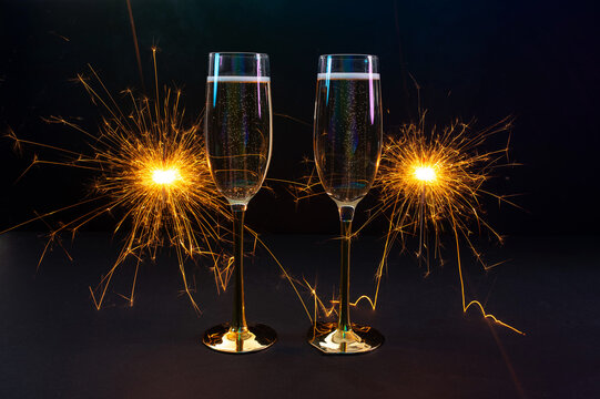 Happy New Year 2026, New Year's Eve holiday greeting card celebration. Sparklers firework, champagne glasses on black background