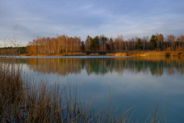 Jesienny krajobraz nad jeziorem z odbiciem brzóz