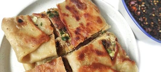 Martabak Telor with Soy Sauce Served On a Plate. Traditional Indonesian Street Food. Food Photography Presentation. Isolated on White Background