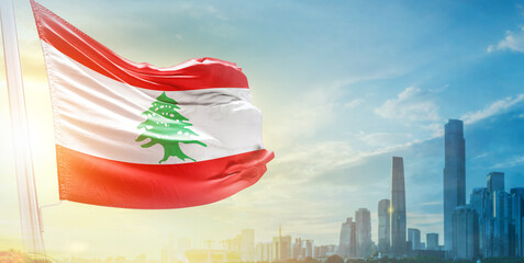 Lebanon flag wavering in beautiful clouds with building skyline. The flag with drone shot in beautiful sky. Lebanon national flag for independence day.
