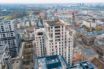 Fototapeta premium Modern skyscraper under construction with crane view