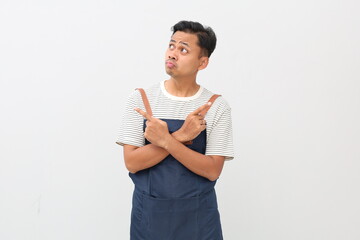 Handsome asian male in apron thinking what do, look sideways thoughtful, cross hands chest pointing left and right, making choice, thinking what pick, taking important decision white background