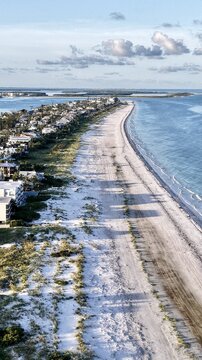Aerial view of the sun-kissed coastline where the soft white sand meets the vast blue ocean, St. Pete Beach, Florida, United States.