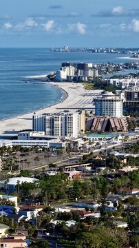 Aerial view of the coastline where the sandy beach meets the azure sea, with buildings lining the shore, St. Pete Beach, Florida, United States.