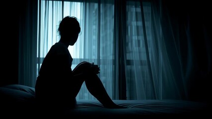 Contemplative silhouette of a woman in a dimly lit room, reflecting on life's challenges