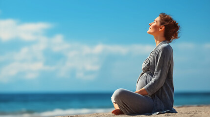 Happy pregnant woman breathing fresh air, relaxing while sitting on the beach against blue sky. Wellness prenatal health concept
