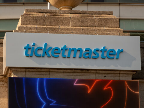 Chicago, Illinois, USA. Nov 12, 2025. Ticketmaster blue logo sign on stone facade above a digital screen showing red and blue light patterns, storefront exterior.