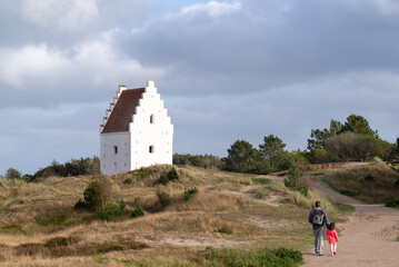 Father and daugther visiting  Den Tilsandede Kirke in Skage, Denmark.