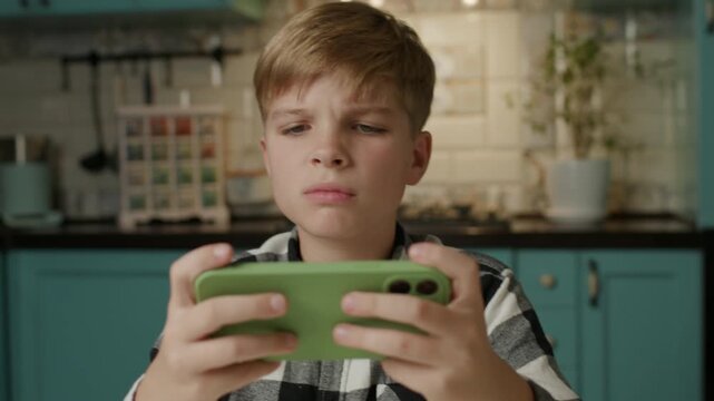 Upset Boy Losing Smartphone Video Game at Home