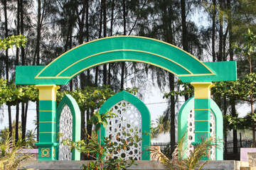 Decorative Islamic-style arch structure painted in green, yellow, and white