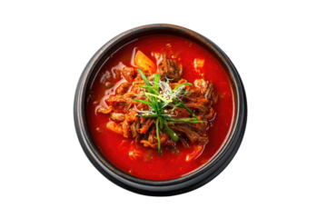 Top-down view of a dark bowl filled with spicy red stew, beef, and chopped scallions