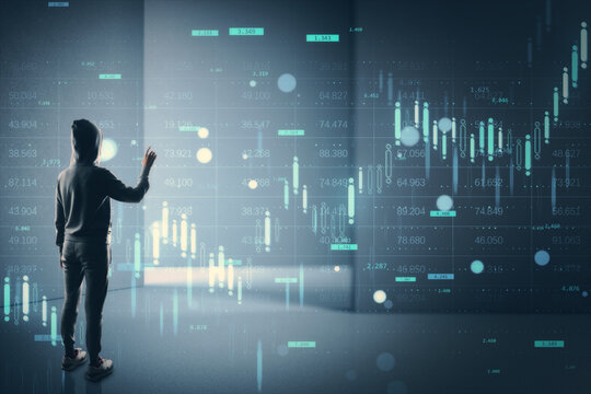Person in hoodie interacting with digital financial chart interface in dark room with glowing market data and stock analysis graphs on background.