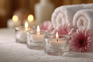 Serene spa setting with candles and rolled towels