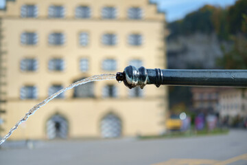 Clean water flowing from the old fountain, selective focus