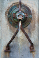 Clean water flowing from the old drinking fountain, selective focus