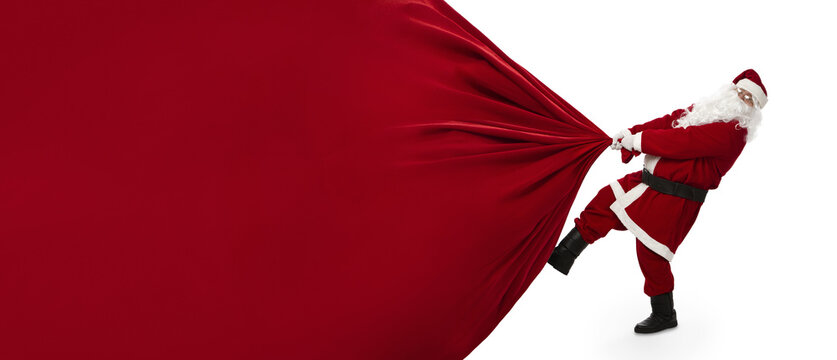 Santa Claus pulling huge bag of presents isiolated on transparent background with copy space, png file