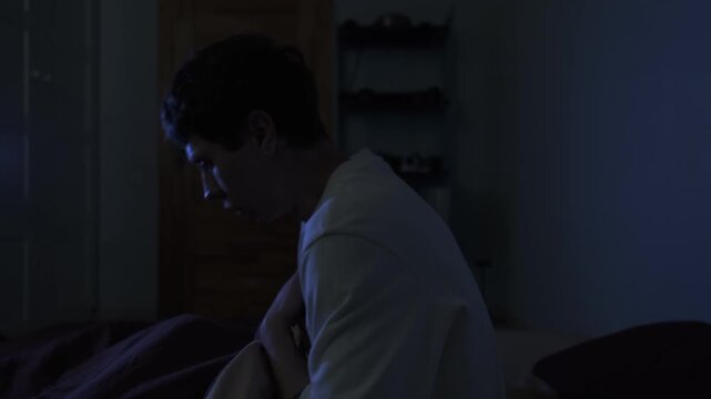 Man waking up from PTSD nightmare, sudden night terror and anxiety in bedroom