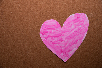 love heart symbol painted pink on a cork board
