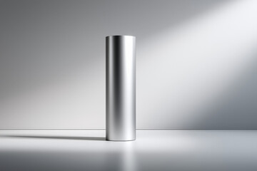 Sleek minimalist silver metal cylinder in soft light on smooth surface