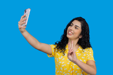 Young woman taking selfie showing peace sign smiling