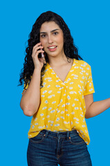 Young woman talking on mobile phone on blue background