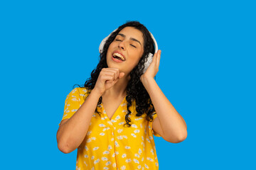 Young woman enjoying music, singing loudly with headphones