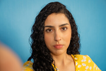 Young woman taking a selfie portrait with serious expression