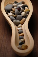 Smooth river stones stacked in a wooden bowl