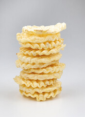 A tower made of corrugated corn chips on a white background. Round corn chips.