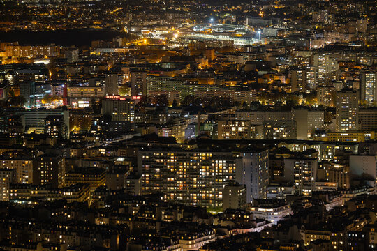 Aerial view of a mesmerizing cityscape illuminated by a tapestry of golden lights, with the Eiffel Tower standing tall against the night sky, Paris, Ile-de-France, France.